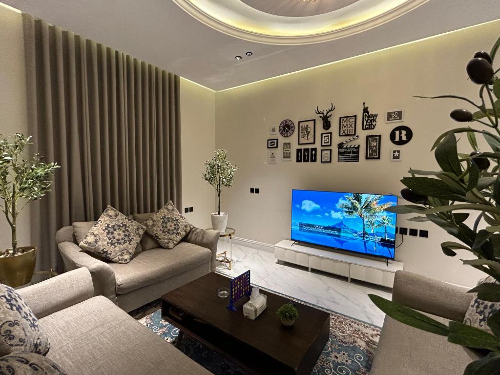 a living room with a couch and a flat screen tv at شقة فاخرة غرفة وصالة بالعارض دخول ذاتي ١٠ in Riyadh