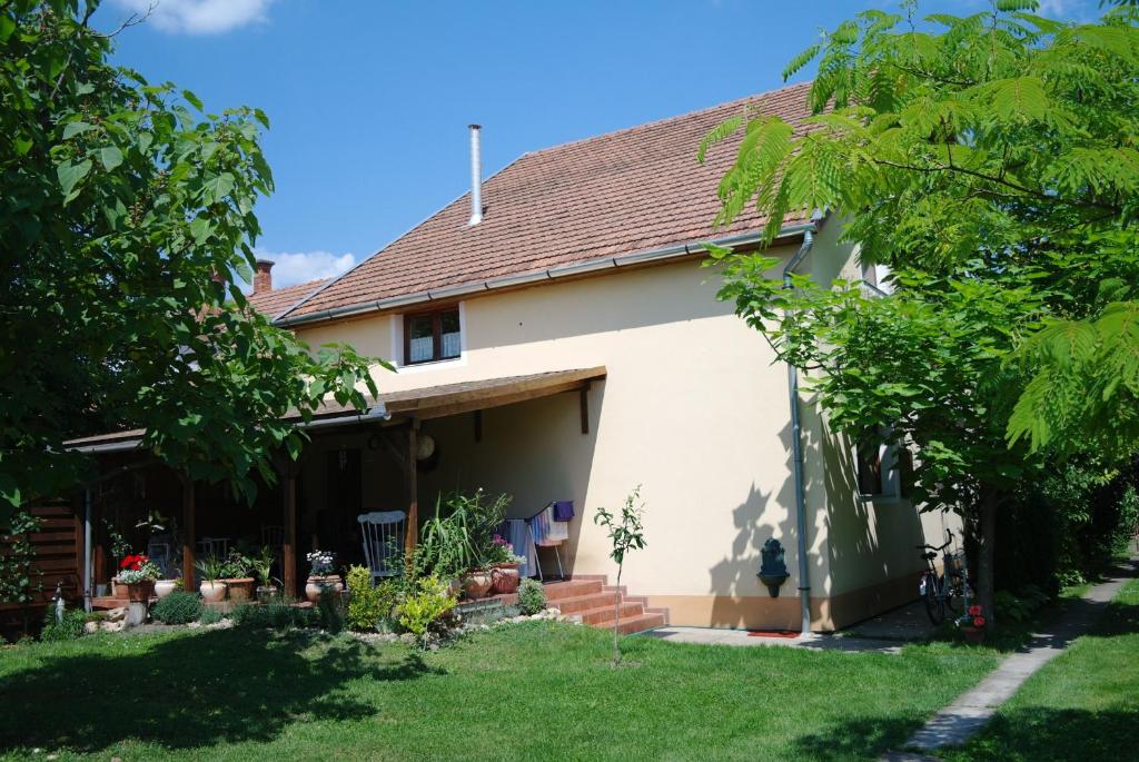 une maison avec un jardin et un arbre dans l'établissement Nóra Apartman, à Gyula