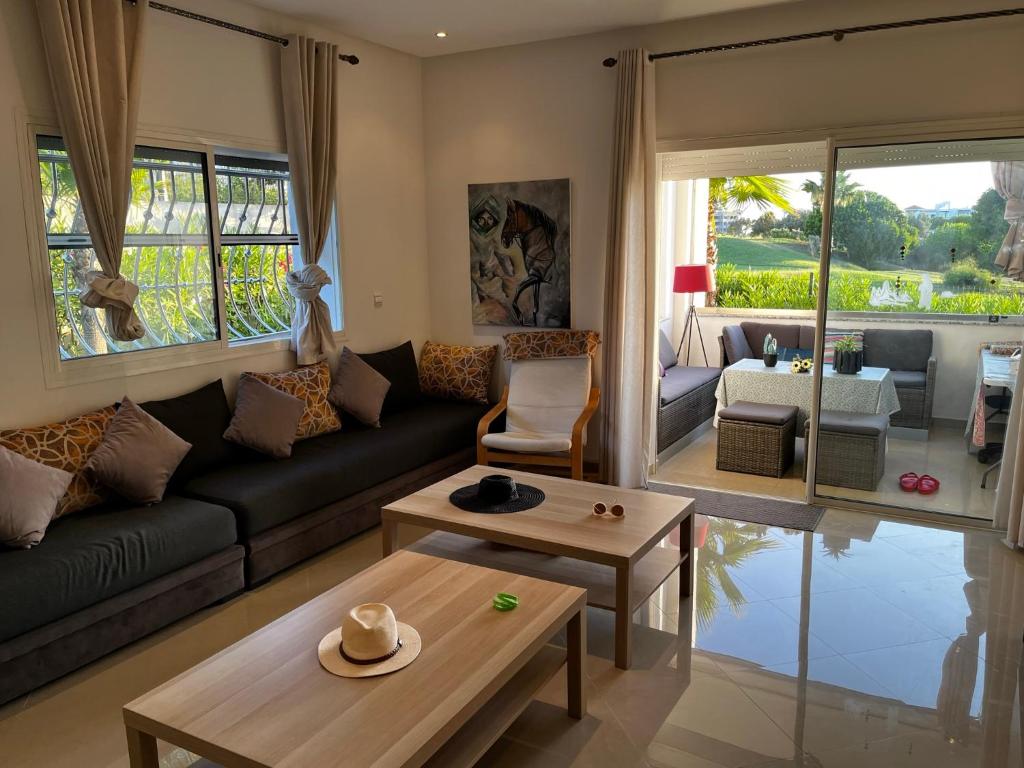 アシラにあるMarina golf ASSILAH vue verteのソファとテーブルのあるリビングルーム