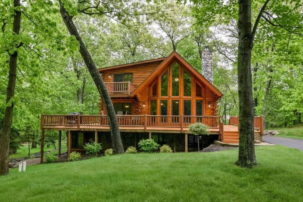 a log cabin in the woods with trees at Home Sweet Log in Wisconsin Dells
