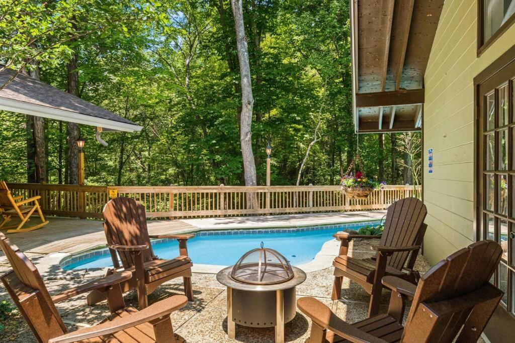 eine Terrasse mit zwei Stühlen und einem Swimmingpool in der Unterkunft Bourbon Hollow Lodge with Hot Tub and Pool plus Game Room only 5 min to downtown in Gatlinburg