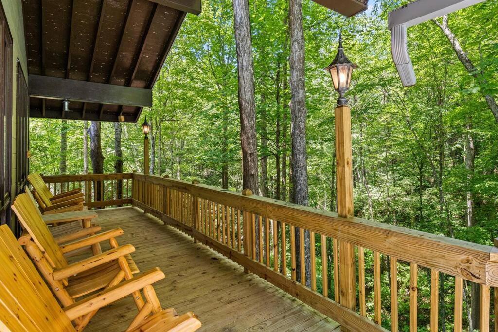 eine Veranda mit zwei Schaukelstühlen und einer Straßenbeleuchtung in der Unterkunft Bourbon Hollow Lodge with Hot Tub and Pool plus Game Room only 5 min to downtown in Gatlinburg
