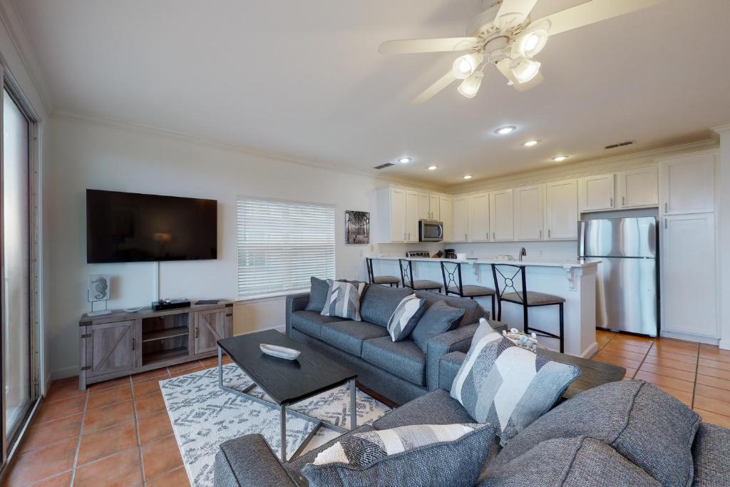a living room with a couch and a tv at Dauphin Island Beach Club 210A in Dauphin Island