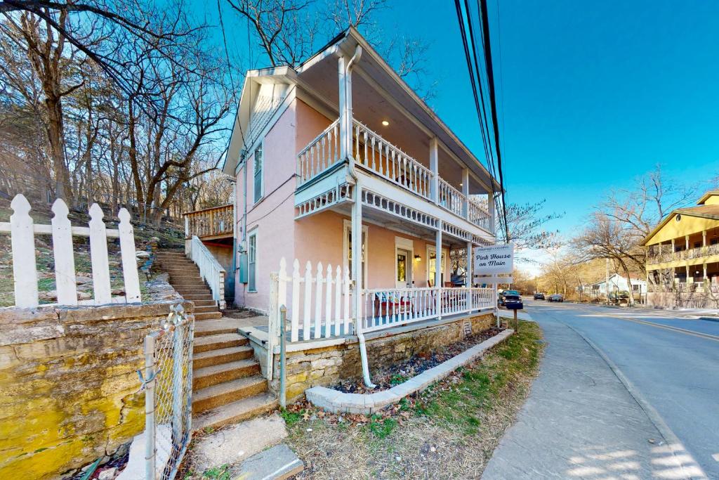 a pink house with a white fence on the street at The Pink House on Main in Eureka Springs
