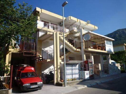 un coche rojo estacionado frente a un edificio en Apartmani Filipović en Bar