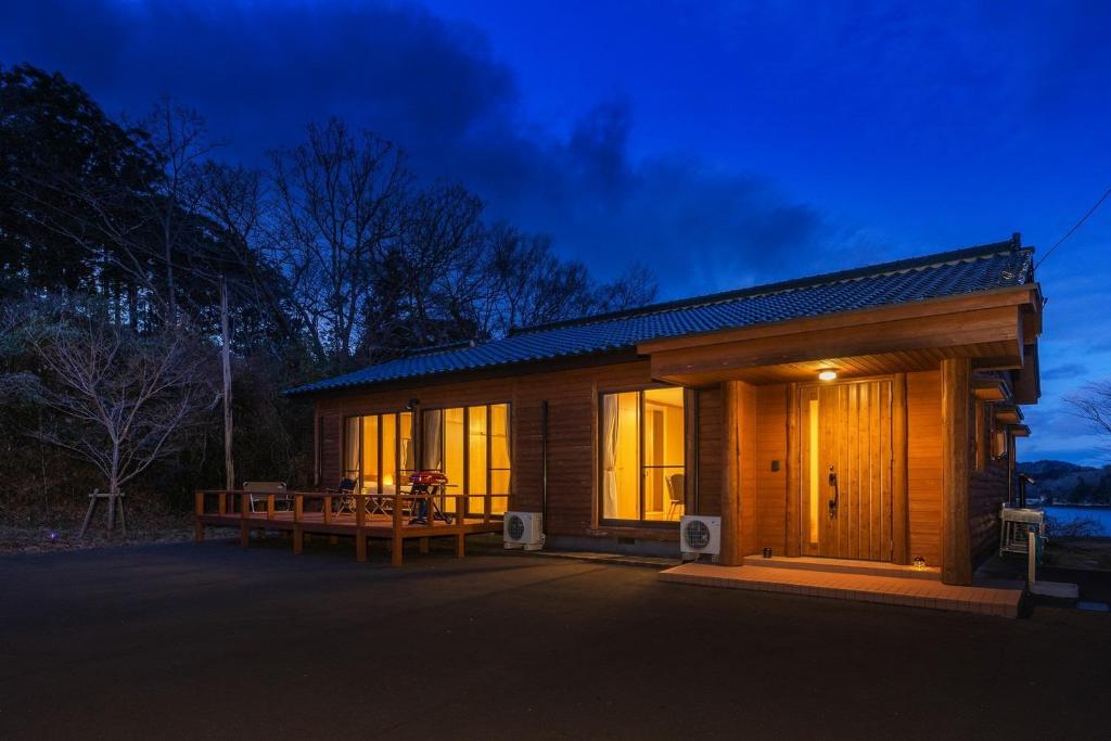 eine kleine Holzhütte mit einer Veranda in der Nacht in der Unterkunft Hermitage Resort Matsushima hibiki - Vacation STAY 14654 