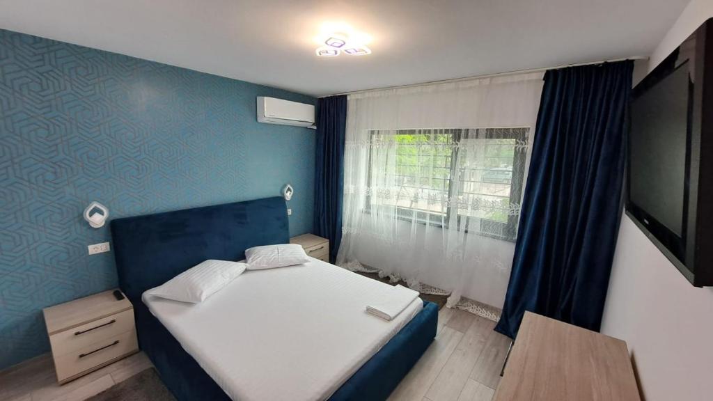 um pequeno quarto com uma cama e uma janela em Apartament lângă Port Turistic Mangalia 2 camere decomandate, renovat 2023 em Mangalia