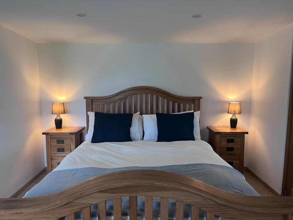 1 dormitorio con 1 cama grande y 2 mesitas de noche en Littlewood Cabin en Hatherleigh