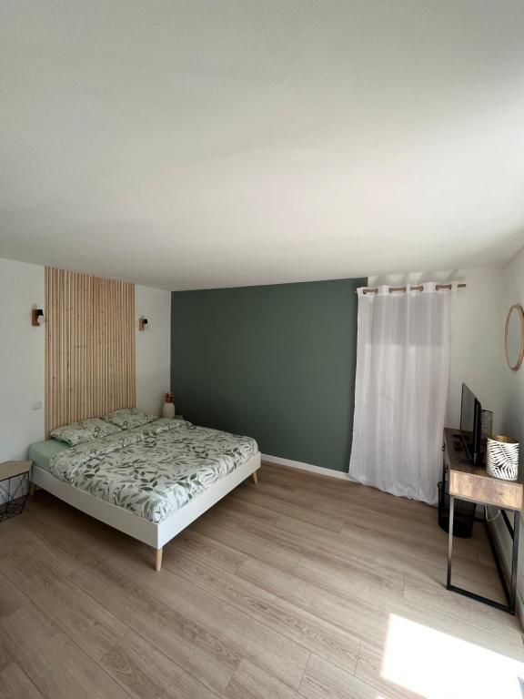 sypialnia z łóżkiem i oknem w obiekcie Le Central : Appartement cosy et calme w mieście Saint-Germain-de-Joux