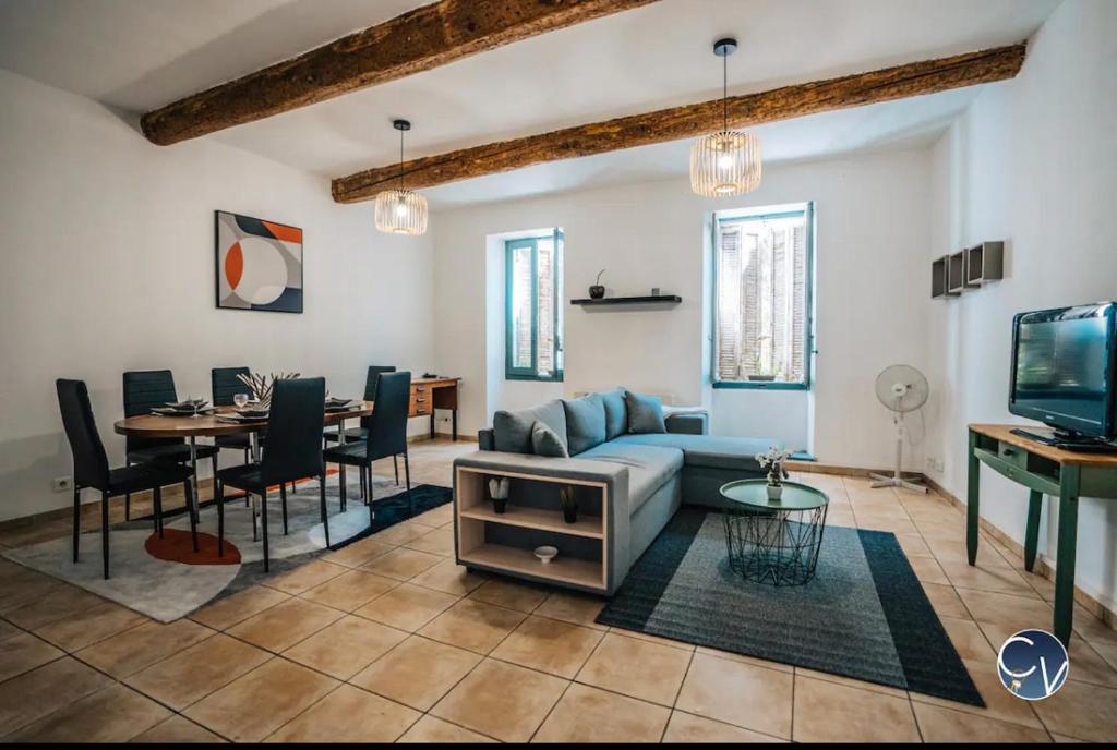 a living room with a couch and a dining room at Appartement cœur de ville aux portes du Luberon in Cavaillon