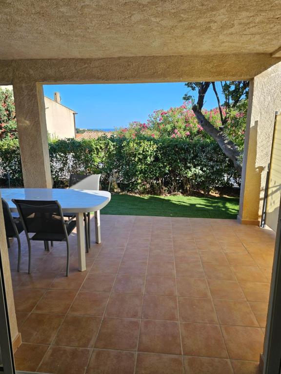 Elle offre une vue sur une terrasse avec une table et des chaises. dans l'établissement Appartement 2 chambres, à Cavalaire-sur-Mer