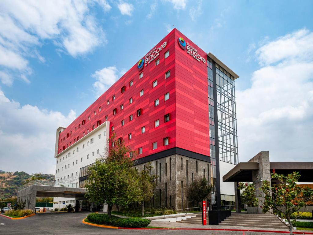 un edificio rojo en el lateral de un edificio en Ramada Encore by Wyndham Guadalajara Sur, en Guadalajara