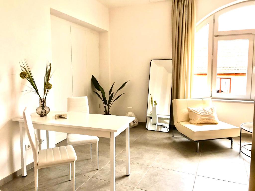 a dining room with a white table and chairs at Atelier Loft Bürgel in Bürgel