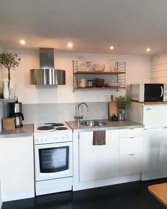 a kitchen with a white stove and a sink at Boende nära havet in Varberg