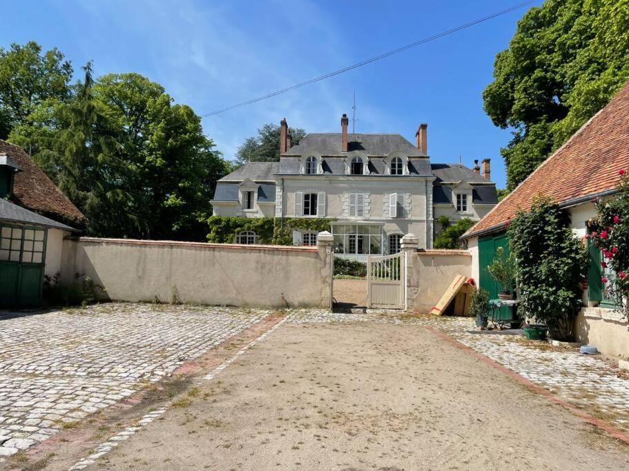 una gran casa blanca con una valla delante en Logement au clos des Fuselières., en Cour-Cheverny