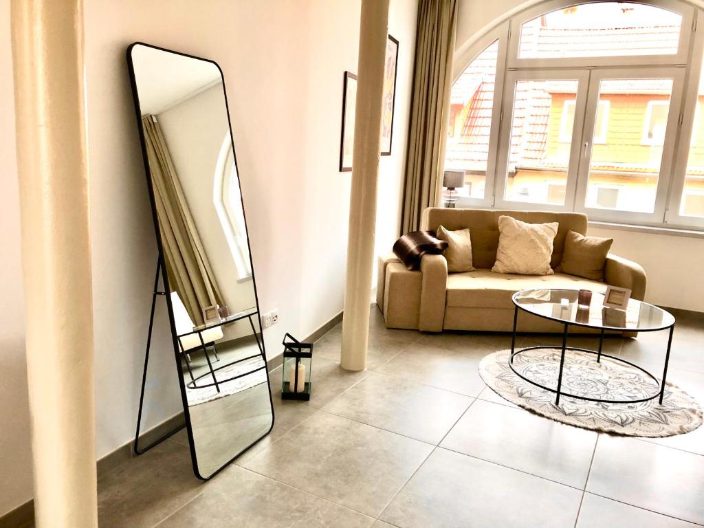 a living room with a mirror and a couch at Apartment Stadtmauer in Bürgel