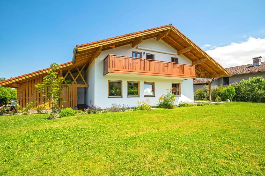 a house with a balcony on top of a yard at Ferienwohnung Am Moosbach in Übersee