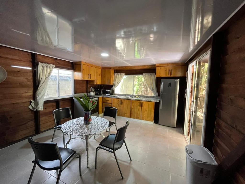 een keuken en eetkamer met een tafel en stoelen bij AO EO little wooden house honeymoon suite in Santiago de los Caballeros
