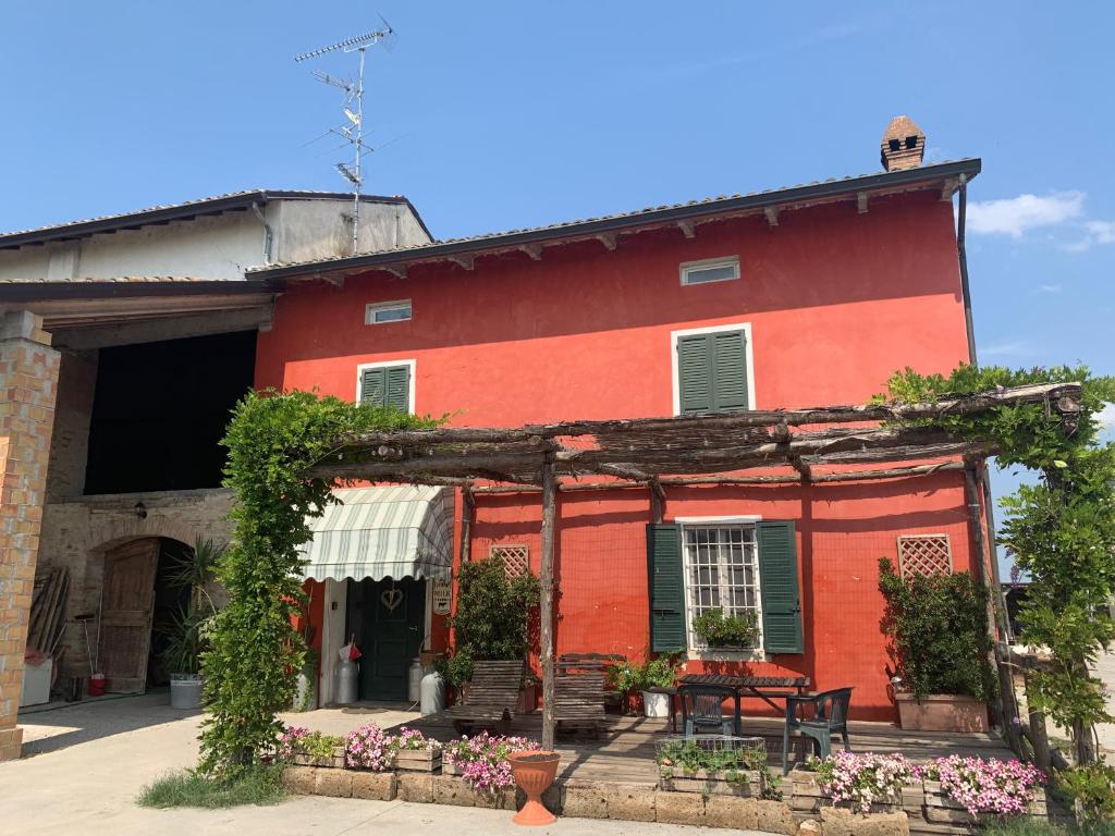 um edifício vermelho com uma mesa em frente em Fattoria Amelia em Santa Caterina