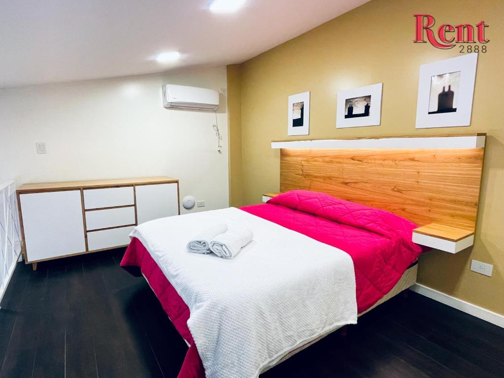 1 dormitorio con 1 cama grande con manta roja en Rent Belgrano en Buenos Aires