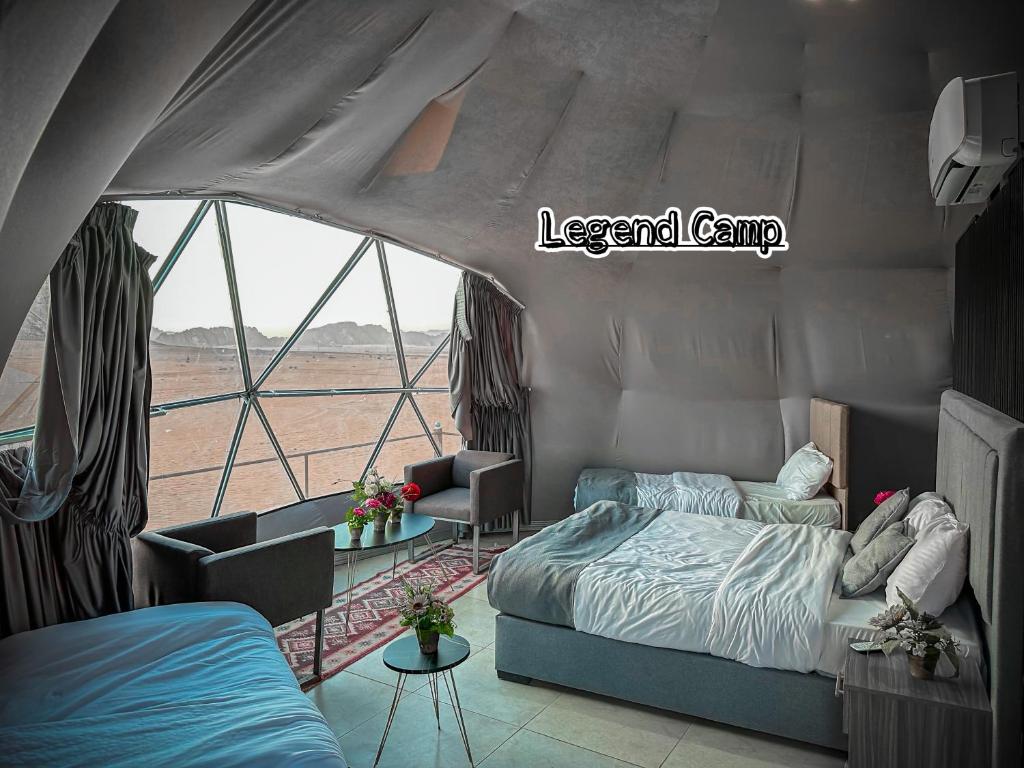 a bedroom with a bed and a large window at Rum Legend camp in Wadi Rum