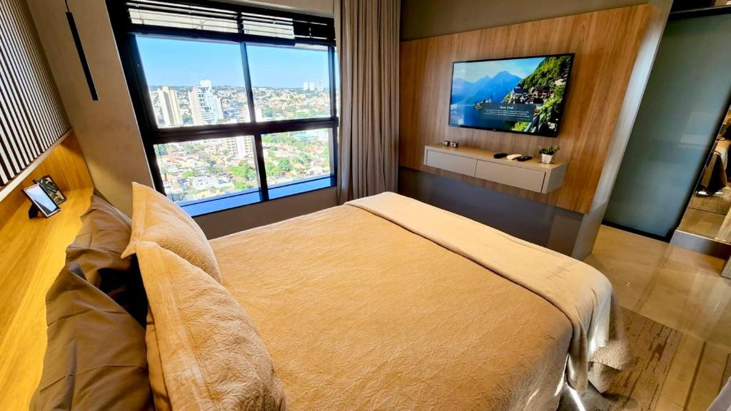 a bedroom with a large bed with a television in it at Luxury Collection By Vertigo 23º Floor in Campo Grande