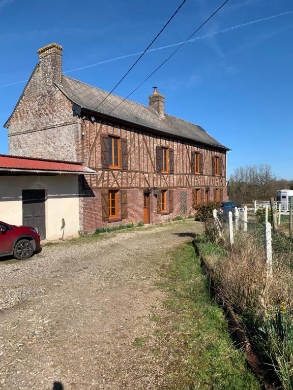 une vieille maison en briques avec une voiture garée devant elle dans l'établissement Chambres d'hôtes, à Beaubec-la-Rosière