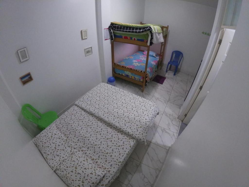 a small room with a table and a crib at Nanasqa Hostel en Nasca / Nazca in Nazca