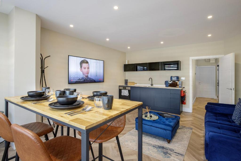 a kitchen and living room with a table and chairs at Five Apartments in Blackpool