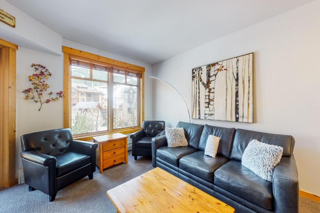 a living room with a leather couch and two chairs at Tucker Mountain Lodge 307 in Copper Mountain