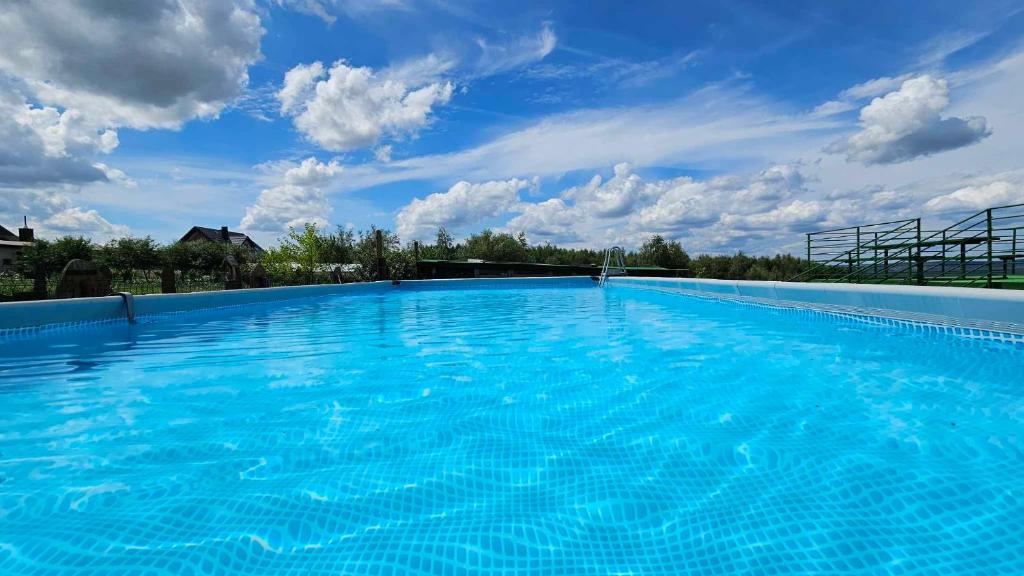 a large blue swimming pool with a blue sky at Noclegi u Banysia w sercu Gór Świętokrzyskich in Krajno Pierwsze