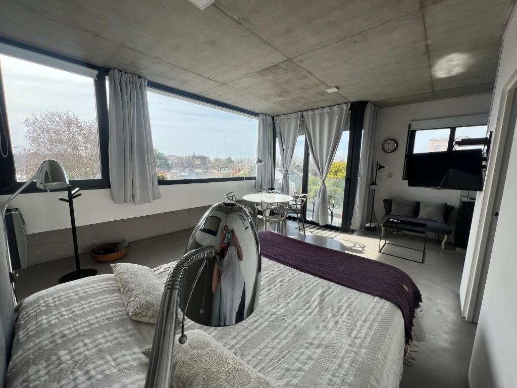a bedroom with a bed and a large window at Hermoso Loft cerca de todo in Remedios de Escalada