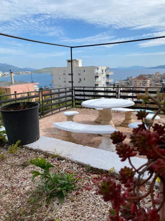 un patio con tavolo e panche sul balcone di Hostel HI Saranda a Sarandë