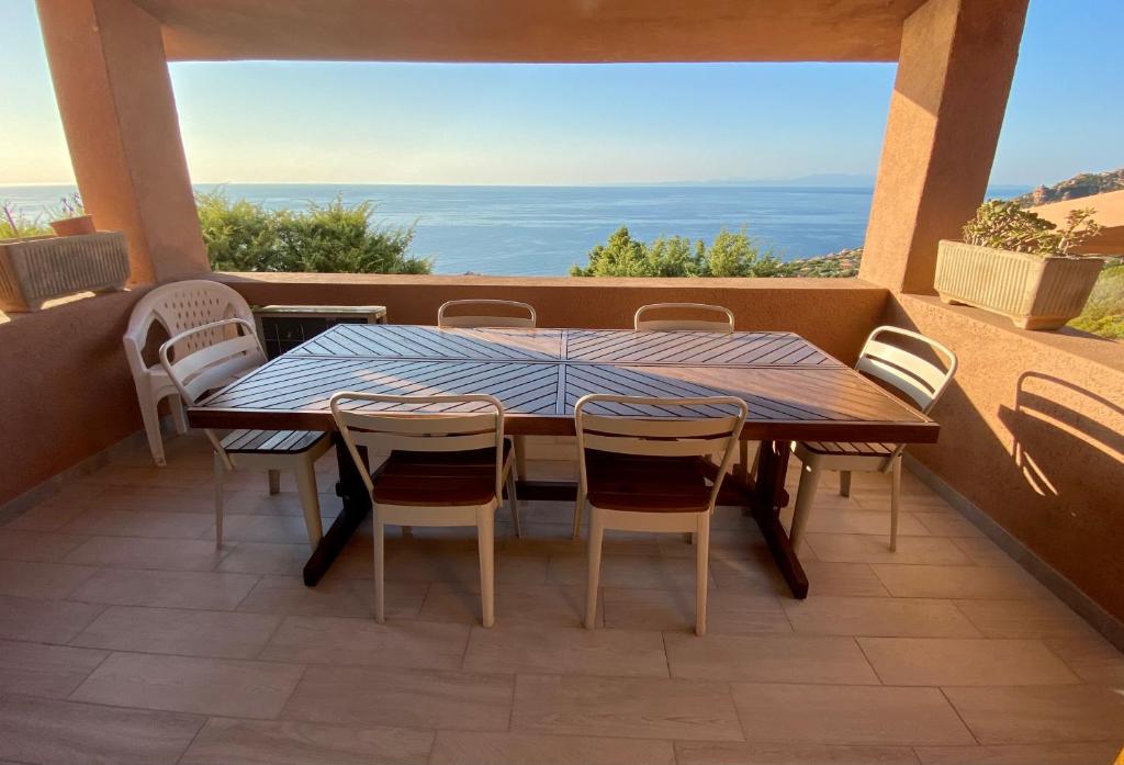 Una mesa y sillas en un balcón con vista al mar. en COSTA PARADISO BELVEDERE APPARTAMENTO Vista Mare, en Costa Paradiso