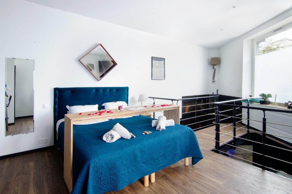 - une chambre avec un lit bleu et un lavabo dans l'établissement Mieuxqualhotel jacuzzi privatif La retro, à Bordeaux