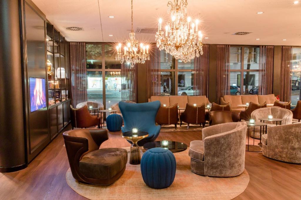 a lobby of a restaurant with blue chairs and tables at Motel One Berlin-Bellevue in Berlin