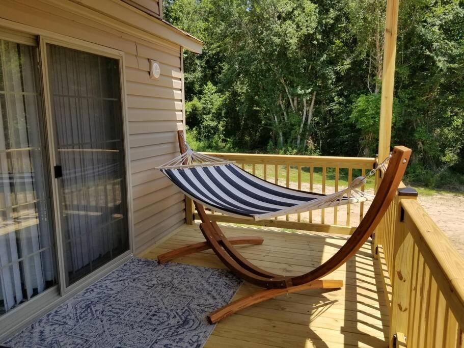 a hammock on the porch of a house at Tiny home with hammock loft BBQ and yard in Phenix City