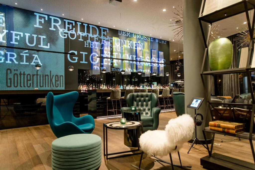a store with green and blue chairs and a table at Motel One Bonn-Beethoven in Bonn