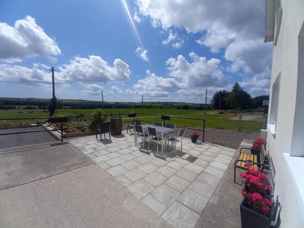 a patio with tables and chairs and a view of a field at Teach na Coille B&B in Midleton