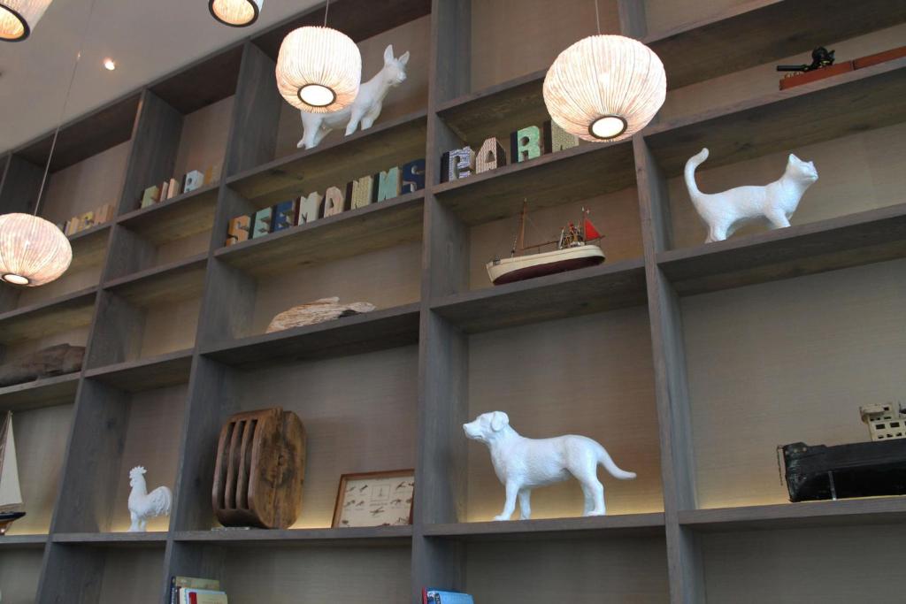 une étagère remplie de figurines de chats blancs et de lumières dans l'établissement Motel One Bremen, à Brême