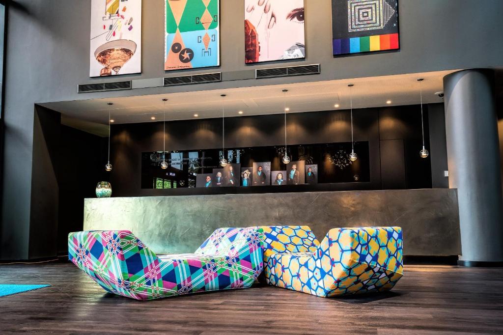 un bar avec deux chaises devant un comptoir dans l'établissement Motel One Wien Westbahnhof, à Vienne