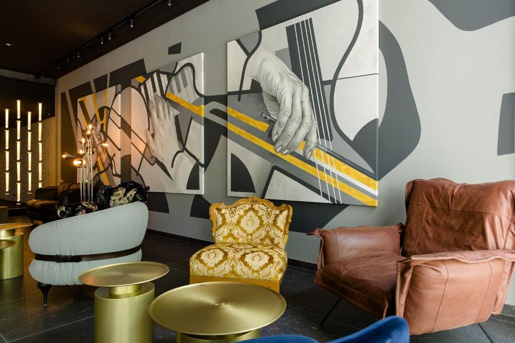 a lobby with chairs and a painting of a skier at Motel One Mannheim in Mannheim