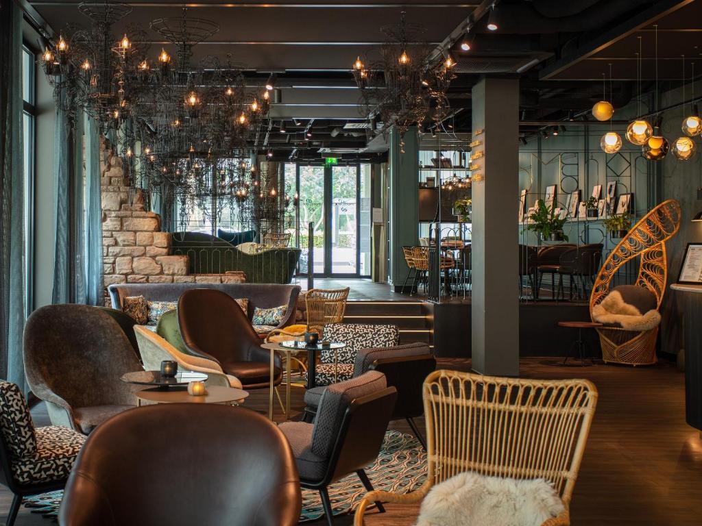 restauracja z krzesłami i stołami oraz bar w obiekcie Motel One Saarbrücken w mieście Saarbrücken