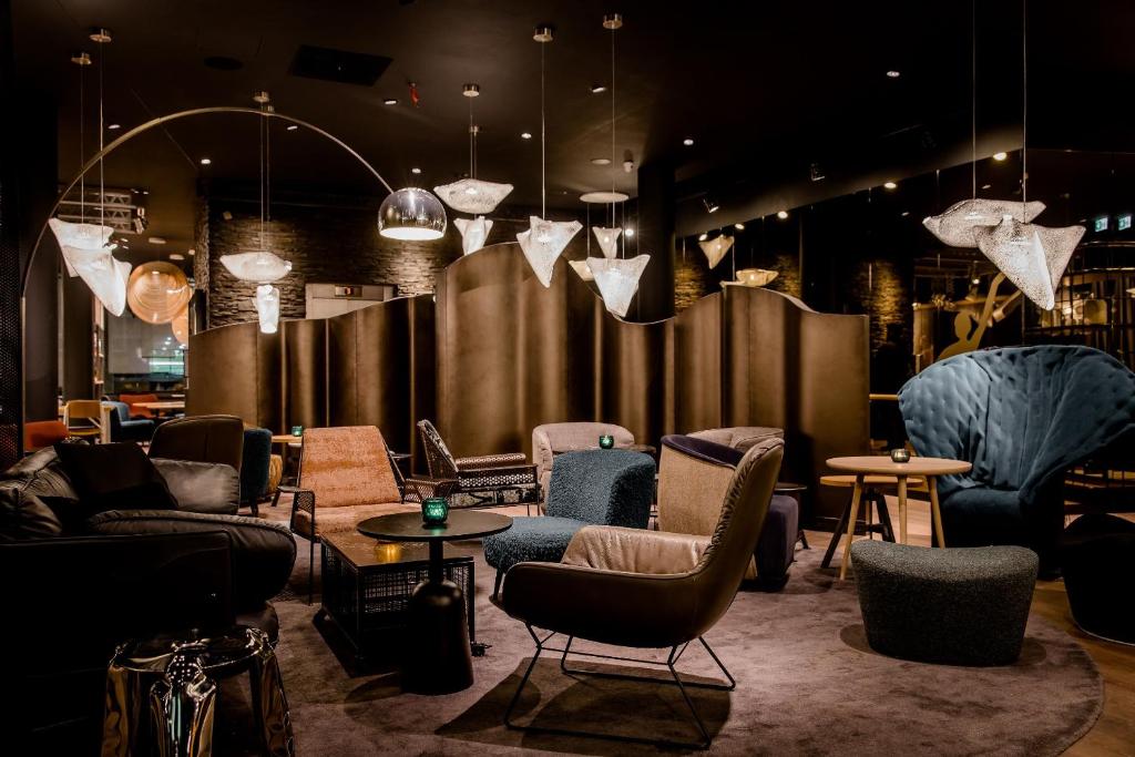 - un hall avec des canapés, des chaises et des tables dans l'établissement Motel One Stuttgart-Mitte, à Stuttgart