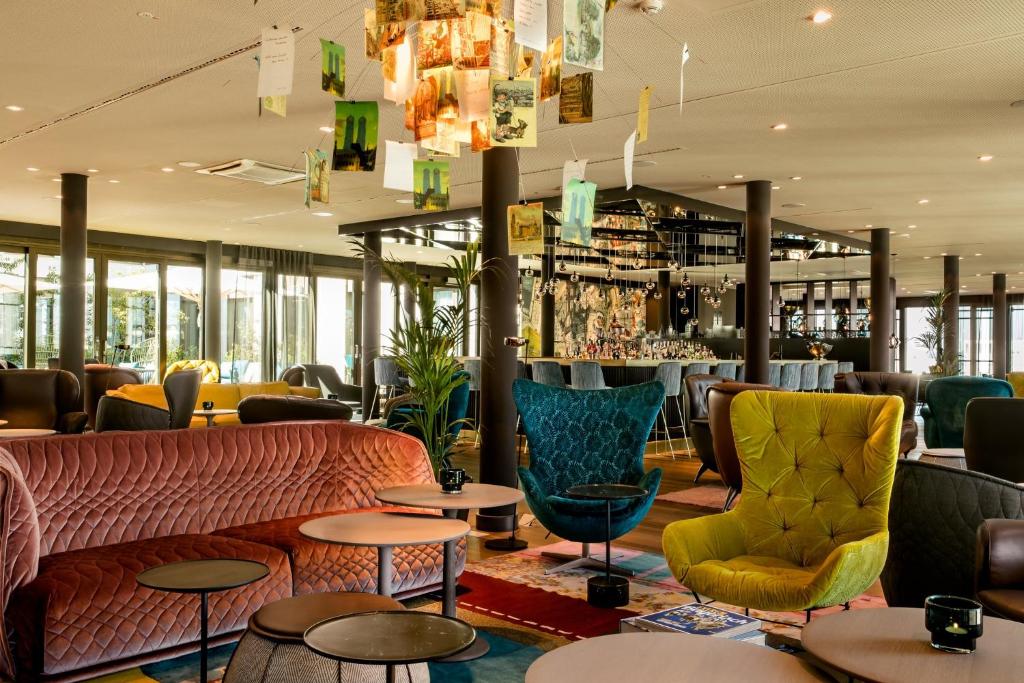 a restaurant with couches and tables and a bar at Motel One München-Messe in Munich