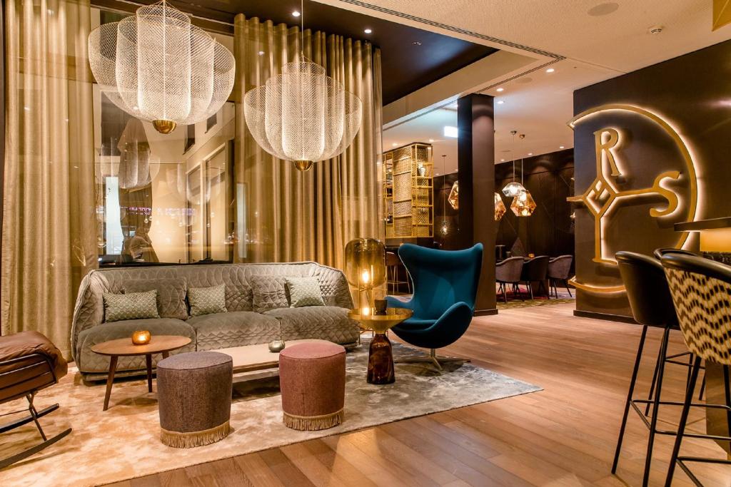 a lobby with a couch and chairs in a store at Motel One Aachen in Aachen