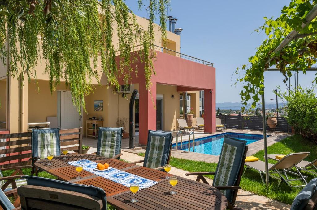 a patio with a table and chairs next to a pool at AnnaBoutique Villa Beach, Heated Private Pool & BBQ in Kato Daratso