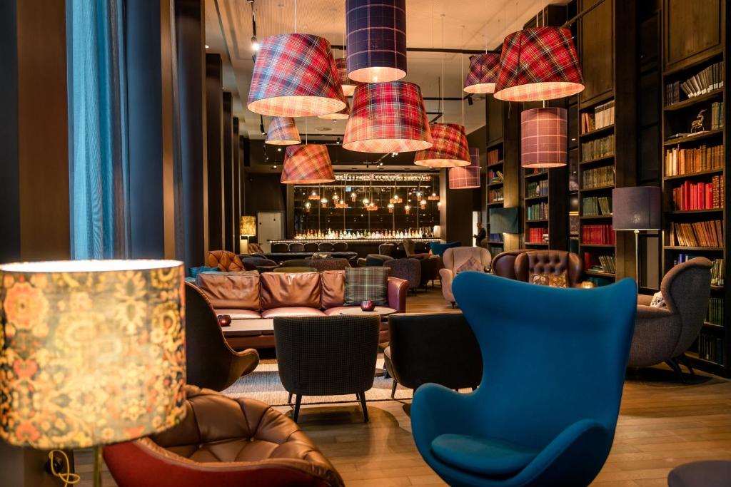 a lobby with a bar with couches and chairs at Motel One Manchester-St. Peter´s Square in Manchester