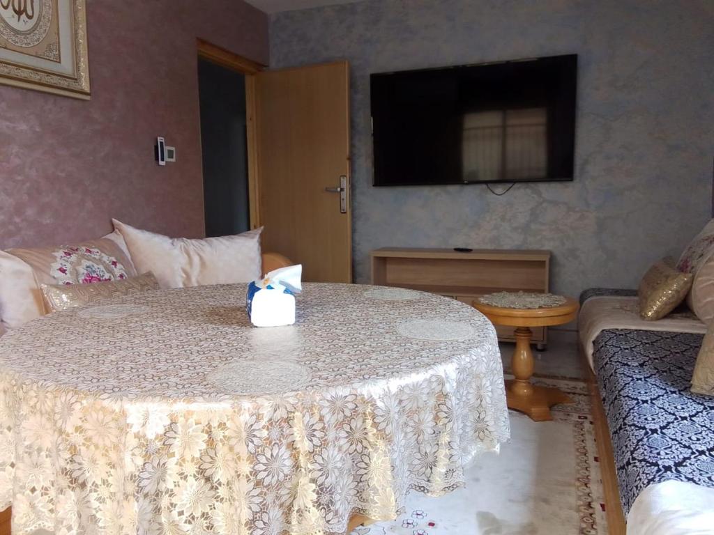 ein Wohnzimmer mit einem Tisch und einem Sofa in der Unterkunft إقامة أحمد 1 in Agadir