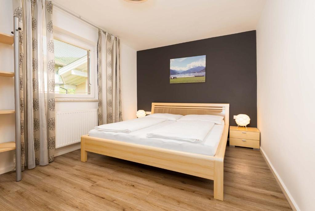 1 dormitorio con cama blanca y ventana en Appartement Am Tatscherlehen, en Piesendorf